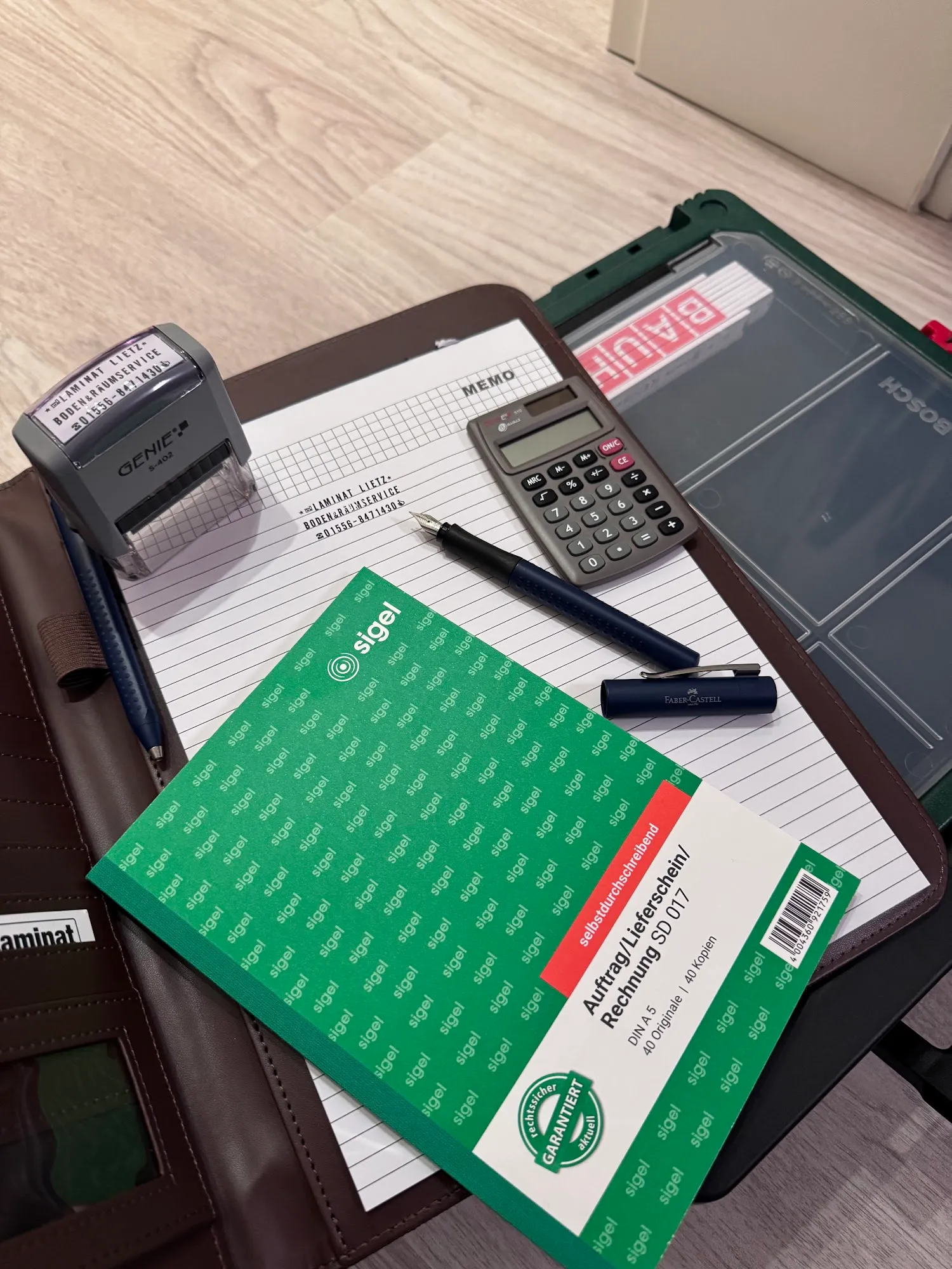 Büroausstattung von Laminat Lietz mit offiziellem Firmenstempel und Auftragsunterlagen